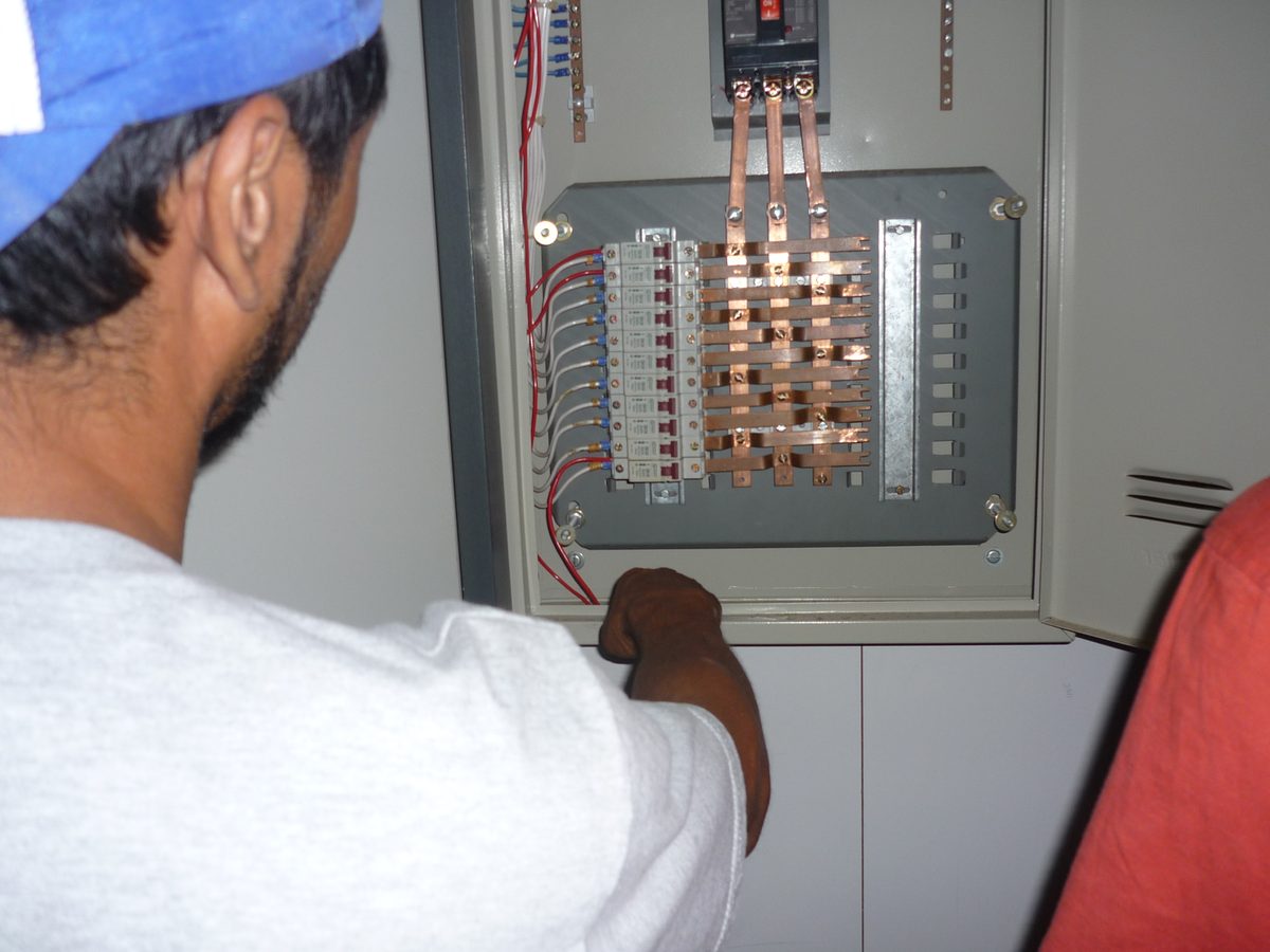 Profissional realizando manutenção em quadro elétrico